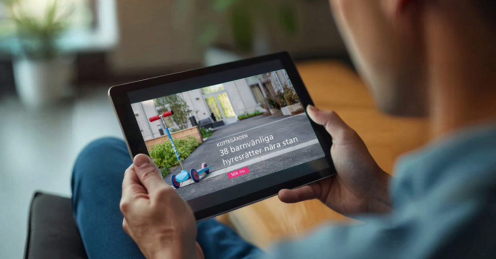 Person håller surfplatta med visualisering av bostadsområde.