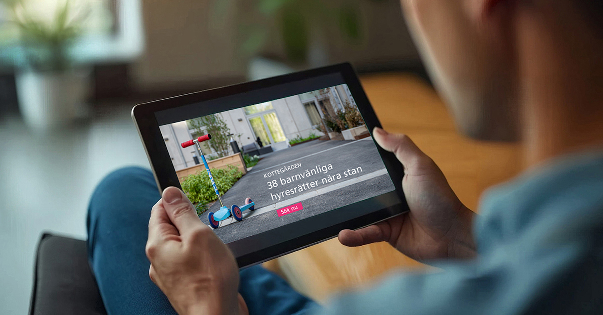 Person håller surfplatta med visualisering av bostadsområde.