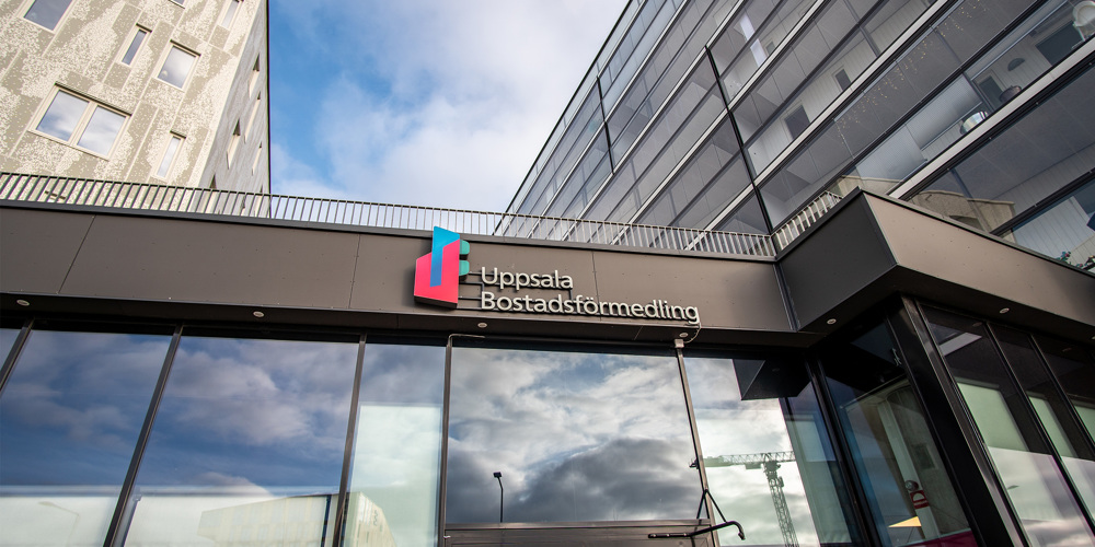 Entré till Uppsala Bostadsförmedling med logotyp på glasfasad.