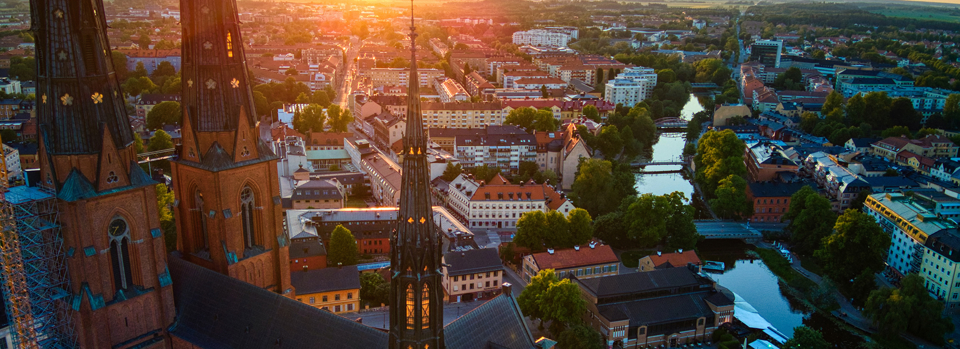 Utsikt över Uppsala i solnedgång med domkyrkan i centrum.